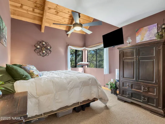 a living room with furniture a flat screen tv and a large window