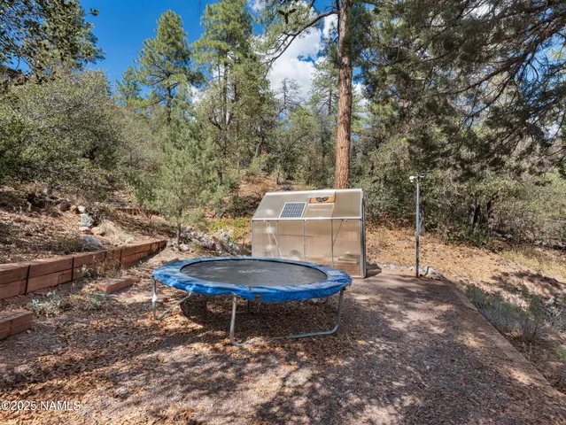 an aerial view of residential house with outdoor space and trees all around