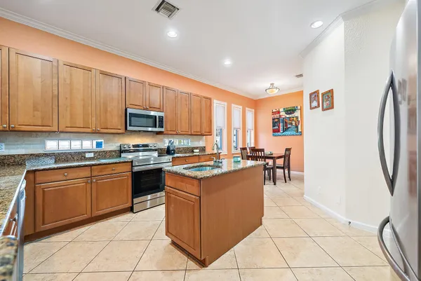 a kitchen with stainless steel appliances granite countertop a refrigerator and a stove top oven