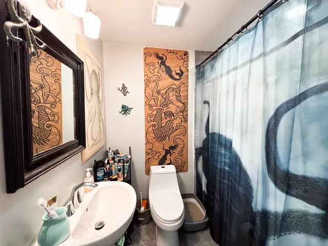 a bathroom with a toilet sink and mirror