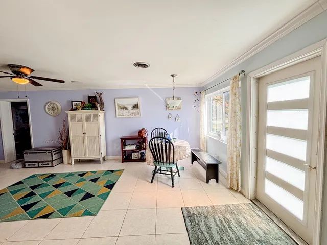 a room with lots of white furniture and a rug