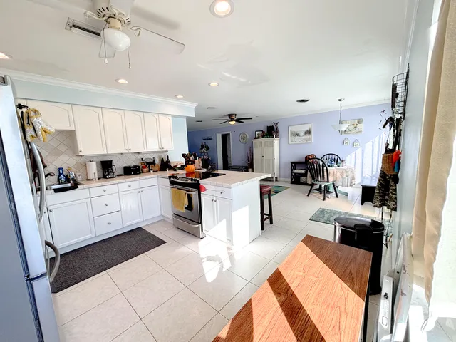 a kitchen with stainless steel appliances kitchen island granite countertop a refrigerator sink and cabinets
