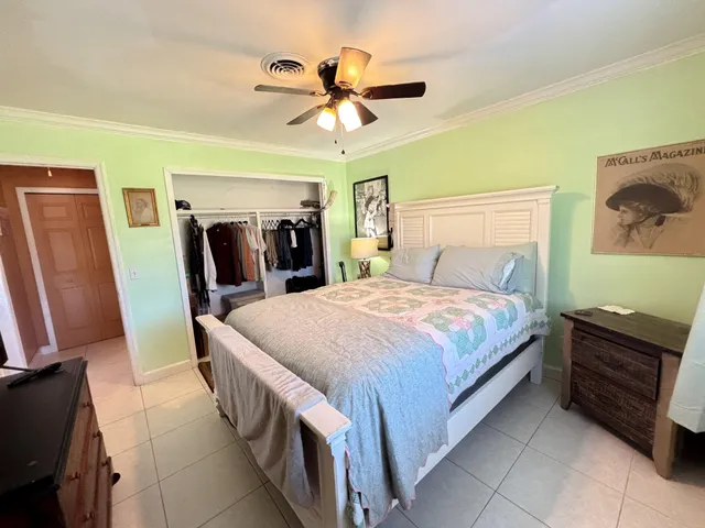 a bed room with a bed and a ceiling fan