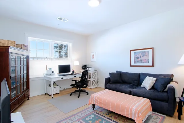 a view of a workspace with furniture and a window