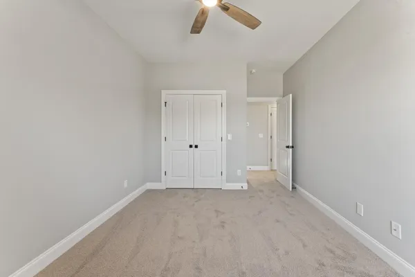 an empty room with chandelier fan
