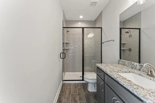 a bathroom with a granite countertop sink a toilet and bathtub