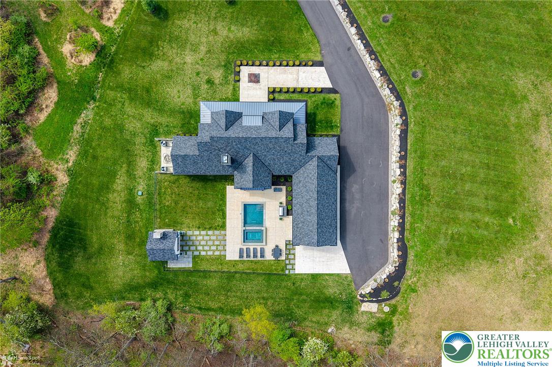 4850 West Hopewell Road Center Valley, PA 18034 - Photo 30 of 96 An aerial perspective showcases the home's dark shingle roof, well-kept grounds, and inviting pool with an adjacent spa.