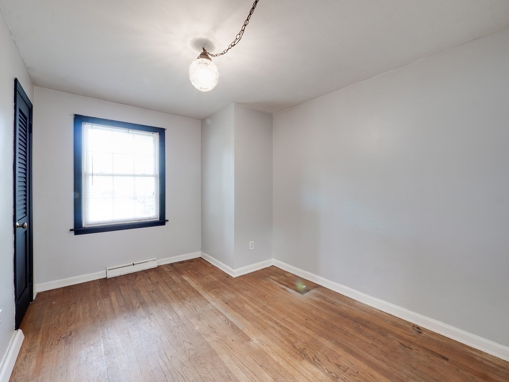 25 French Street Springfield, MA 01104 - Photo 13 of 16 an empty room with wooden floor and windows