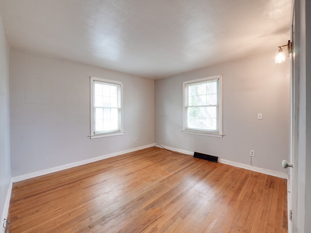 25 French Street Springfield, MA 01104 - Photo 15 of 16 an empty room with wooden floor and windows