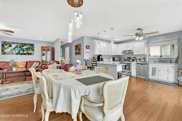 a kitchen with stainless steel appliances kitchen island granite countertop a table chairs and a view of living room