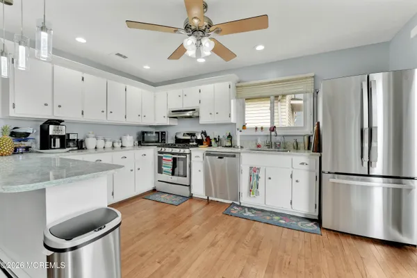 a kitchen with white cabinets and stainless steel appliances