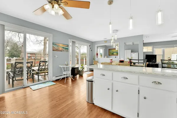 a large white kitchen with granite countertop a large window and white appliances