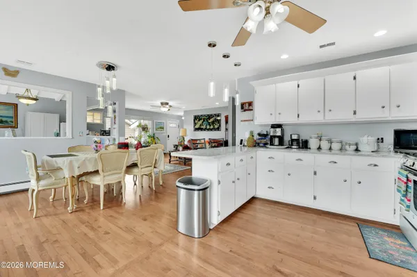 a kitchen with white cabinets and chairs