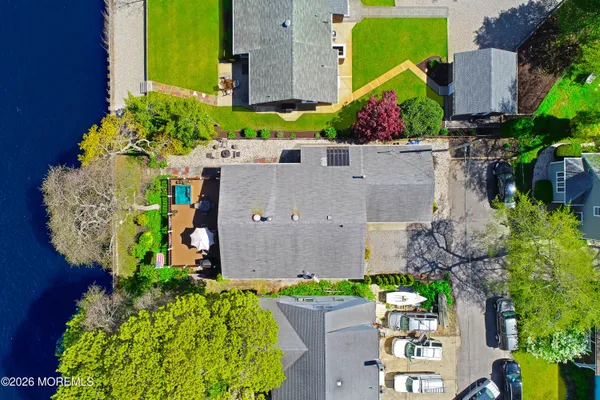 an aerial view of a house with a yard and a large tree