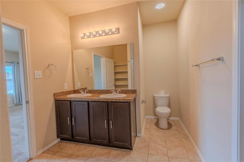 5157 Grayson Ridge Drive Fort Worth, TX 76179 - Photo 20 of 34 a bathroom with a granite countertop sink and a mirror