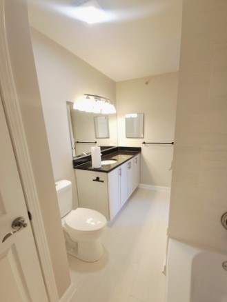 501 Leah Lane, Unit 2A Woodstock, IL 60098 - Photo 11 of 13 a bathroom with a granite countertop sink toilet and a mirror