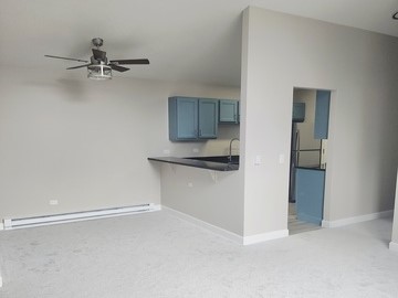 501 Leah Lane, Unit 2A Woodstock, IL 60098 - Photo 5 of 13 a view of a room with an empty space and a ceiling fan