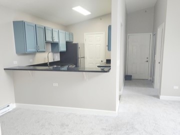 501 Leah Lane, Unit 2A Woodstock, IL 60098 - Photo 6 of 13 a view of a kitchen with wooden cabinets