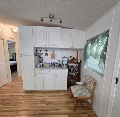 a kitchen with stainless steel appliances a dining table chairs refrigerator and microwave