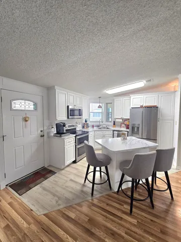 a kitchen with stainless steel appliances granite countertop a refrigerator a stove a sink and a microwave