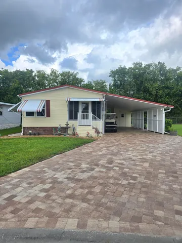 a view of a house with a yard and sitting area