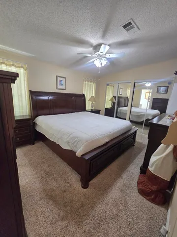 a bedroom with a large bed and a chandelier