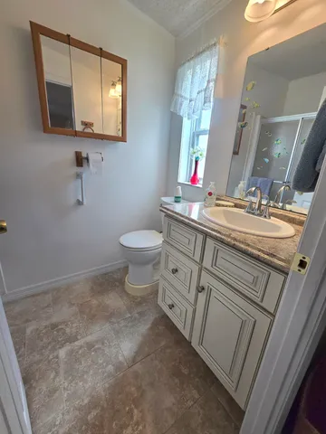 a bathroom with a sink a toilet and a mirror