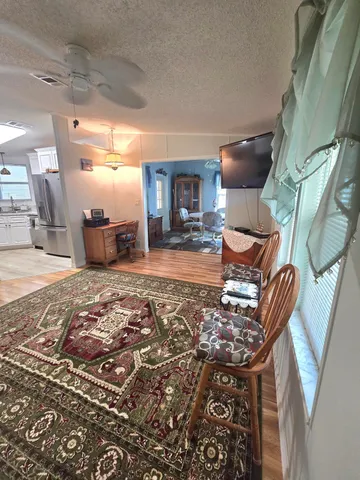 a dining room with wooden floor and large windows