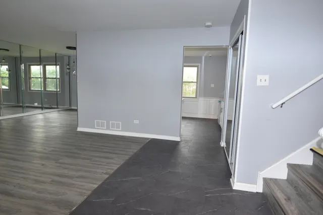an empty room with wooden floor and a fireplace