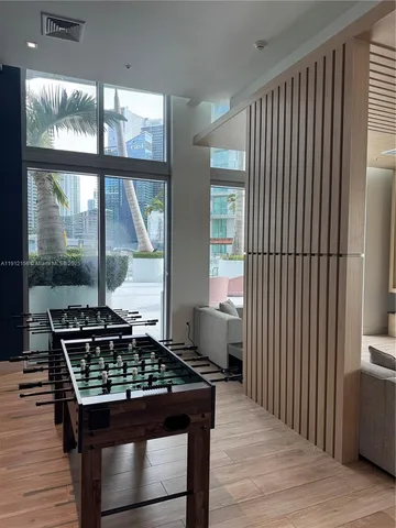 a view of a hallway with wooden floor and a bathroom