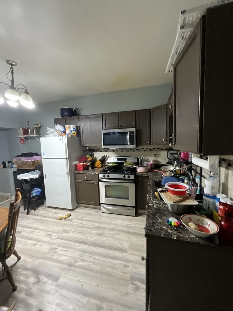 4226 West Ogden Avenue Chicago, IL 60623 - Photo 15 of 20 a kitchen with a refrigerator a stove top oven a sink and dishwasher