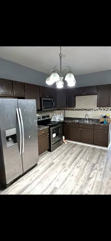 a kitchen with kitchen island stainless steel appliances a stove and a sink