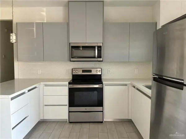 a kitchen with white cabinets and stainless steel appliances