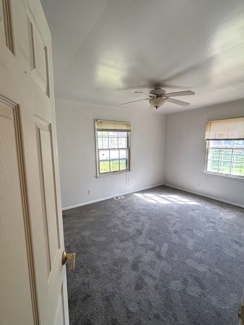 22 Guilford Road Montgomery, IL 60538 - Photo 8 of 14 an empty room with windows and fan