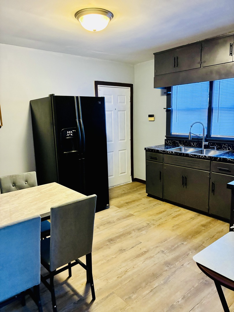 14506 Clinton Street Harvey, IL 60426 - Photo 7 of 12 a kitchen with a table and refrigerator
