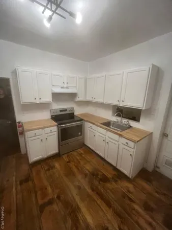 a kitchen with granite countertop white cabinets and white appliances