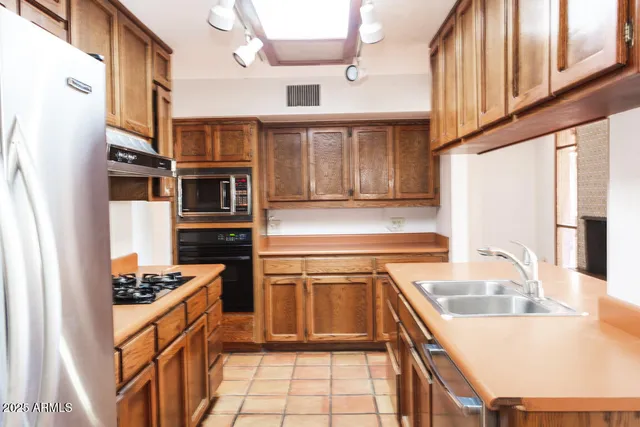 a kitchen with stainless steel appliances granite countertop a sink and a stove