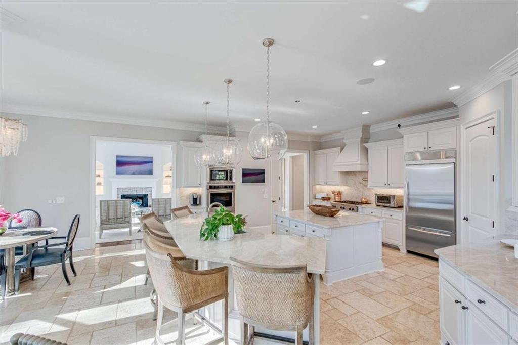 6226 Random Winds Bluff Gainesville, GA 30506 - Photo 24 of 76 a kitchen with stainless steel appliances kitchen island granite countertop a table and chairs in it