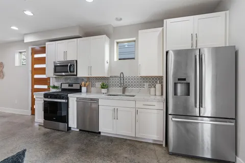 a kitchen with stainless steel appliances a refrigerator sink and microwave