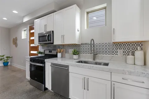 a kitchen with a sink a stove and cabinets