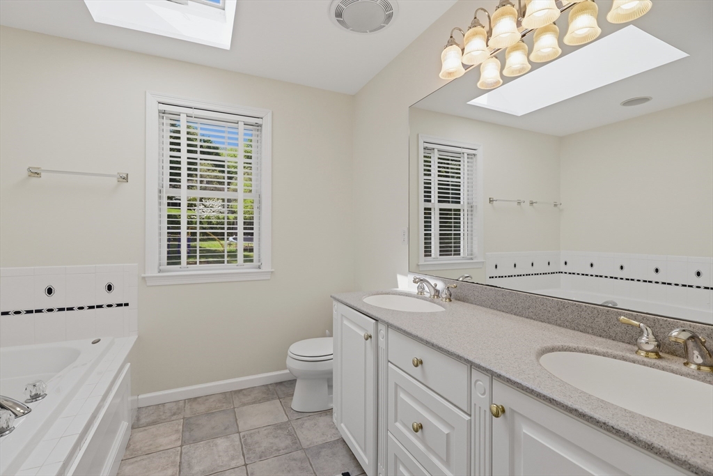 61 Indian Head Road Framingham, MA 01701 - Photo 31 of 42 a bathroom with a granite countertop double vanity sink a mirror and a bathtub