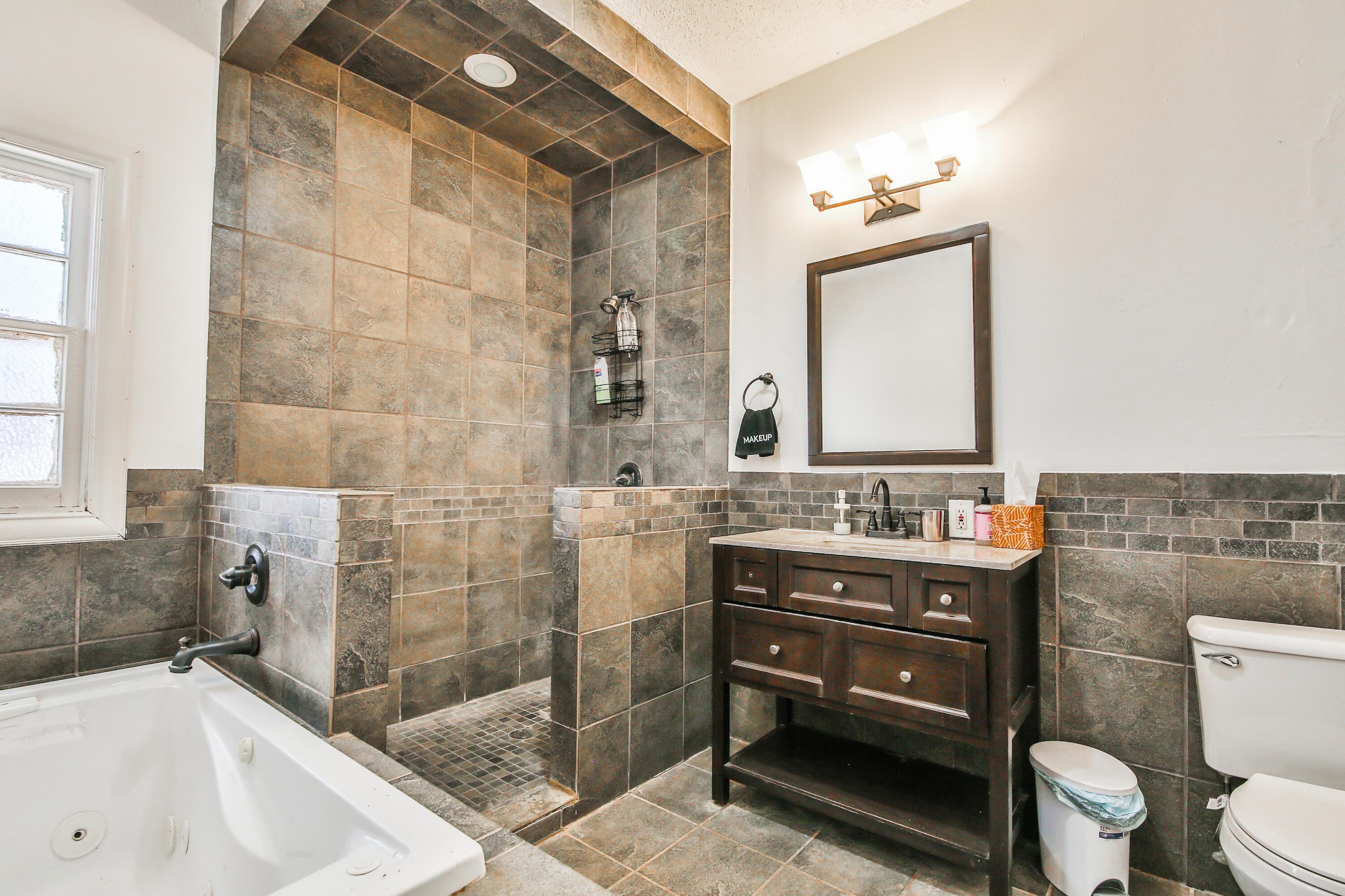 2309 17th Street Lubbock, TX 79401 - Photo 12 of 26 a bathroom with a sink a toilet and shower