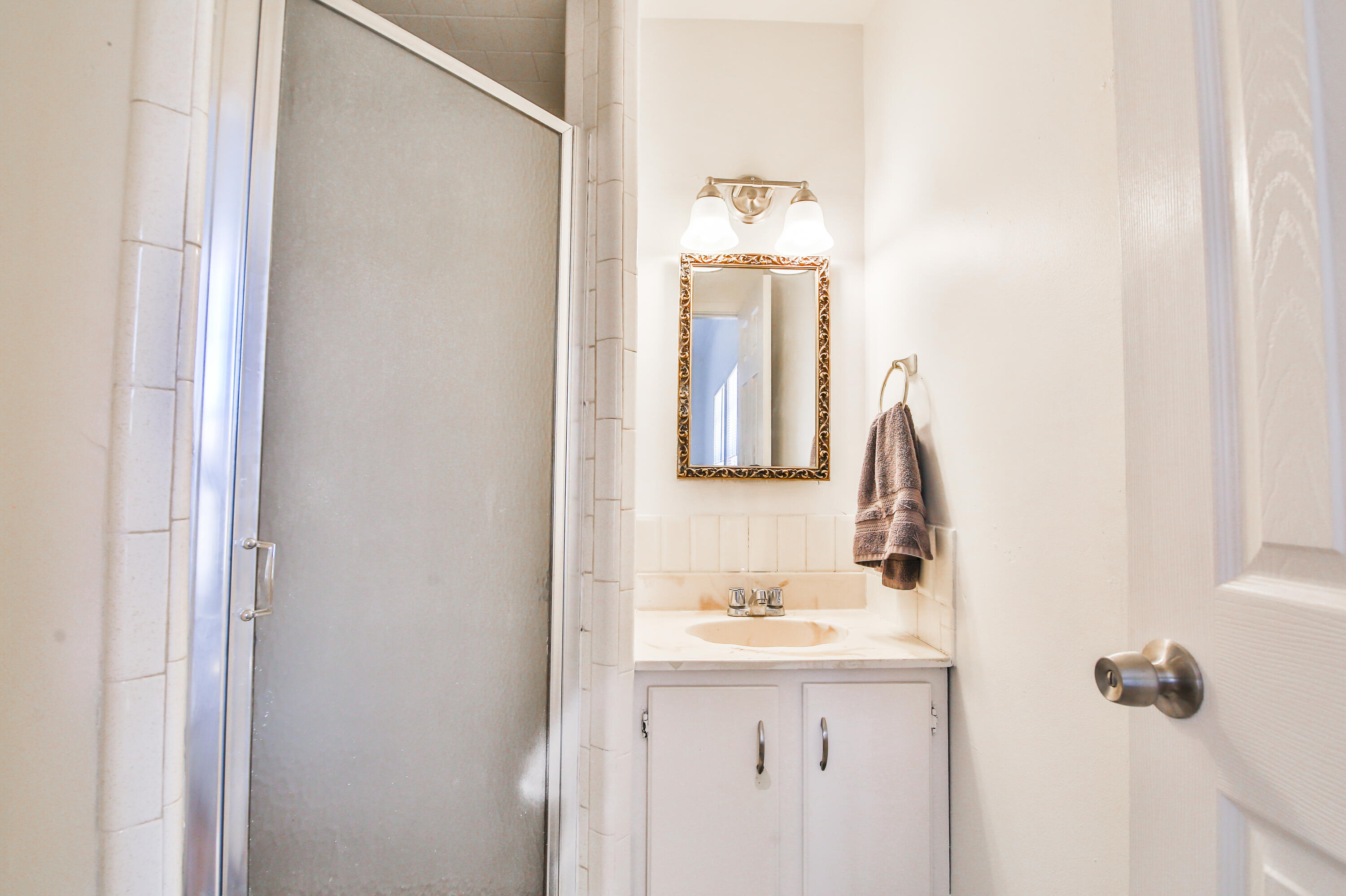 2309 17th Street Lubbock, TX 79401 - Photo 14 of 26 a bathroom with a sink and mirror with toilet