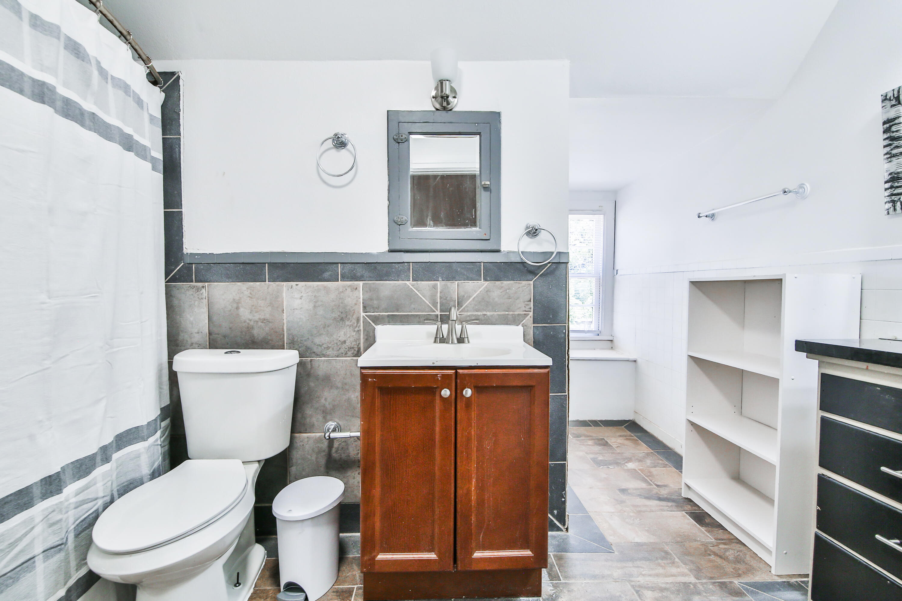 2309 17th Street Lubbock, TX 79401 - Photo 17 of 26 a bathroom with a toilet a sink and a mirror