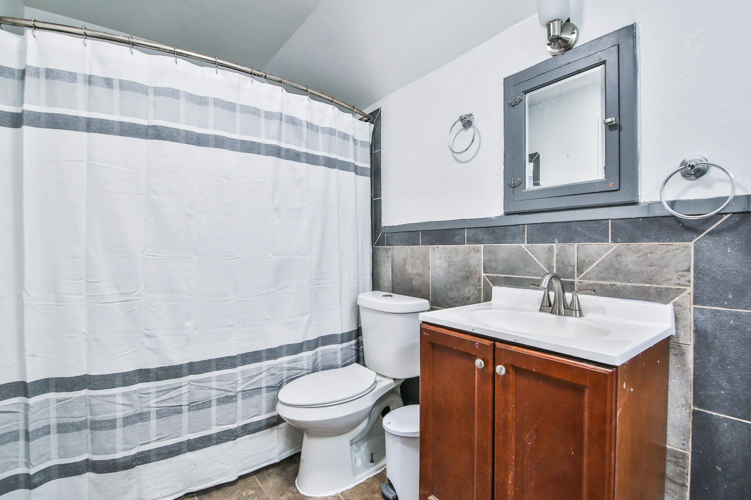 2309 17th Street Lubbock, TX 79401 - Photo 18 of 26 a bathroom with a sink vanity mirror and toilet