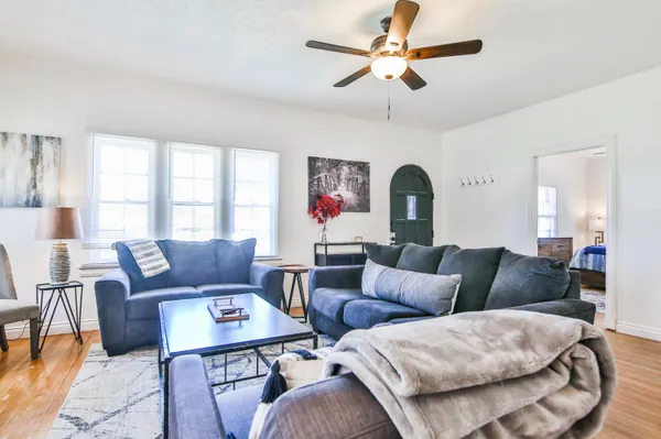 a living room with furniture a chandelier and a window