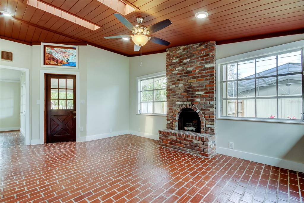 2901 Pelham Road North St. Petersburg, FL 33710 - Photo 11 of 32 a living room with a fireplace furniture a ceiling fan and a window