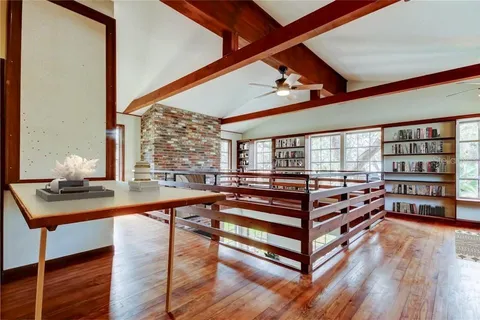 a view of a room with gym equipment and wooden floor