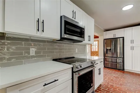 a kitchen with stainless steel appliances a stove a microwave and a sink