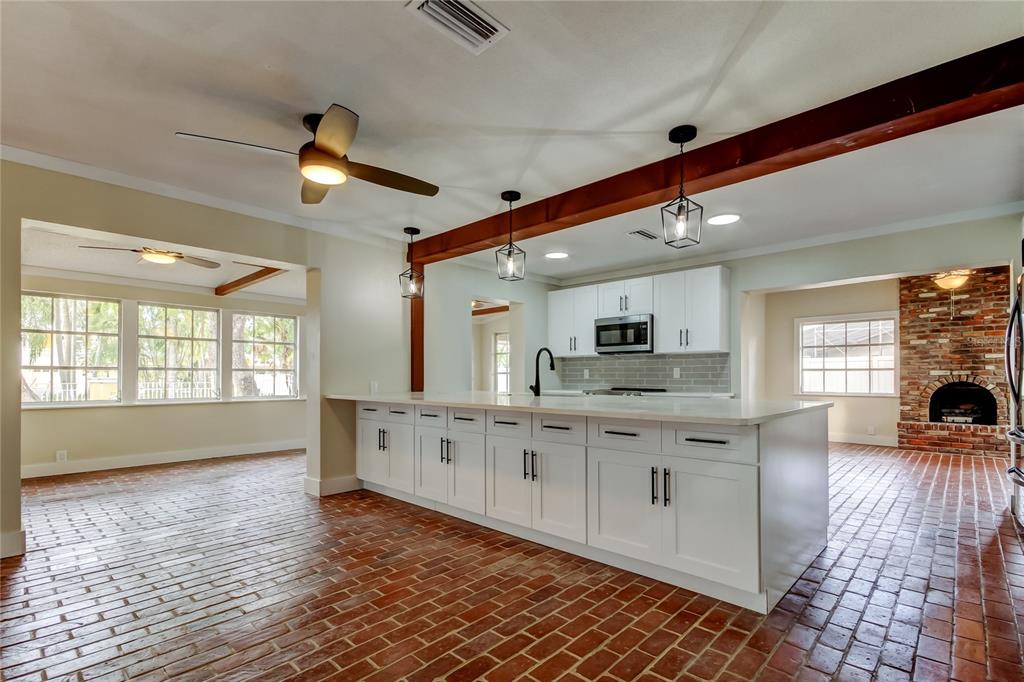2901 Pelham Road North St. Petersburg, FL 33710 - Photo 7 of 32 a large kitchen with stainless steel appliances a large counter top a sink a window and a fireplace